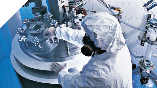 Scientist in gas mask using lab equipment.